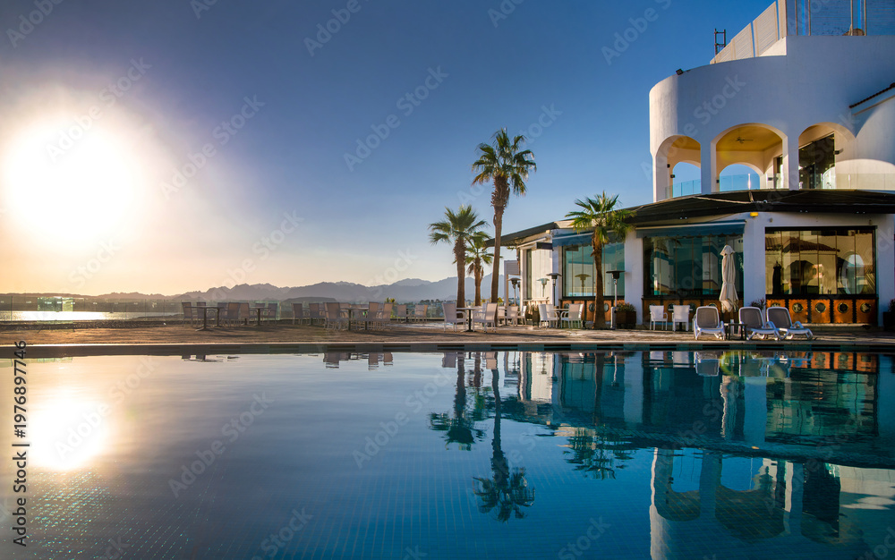 Fototapeta premium Sunset over the pool overlooking the sea 