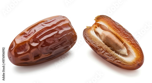 Two brown dates one cut open on white background showing ajaa