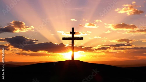 Silhouette of an Orthodox Cross on a Hill Against a Radiant Golden Sunset Sky