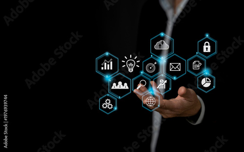 Businessman hand holding virtual hexagon digital interface with business icons. Concept of innovation, global networking, strategic planning, and digital transformation.