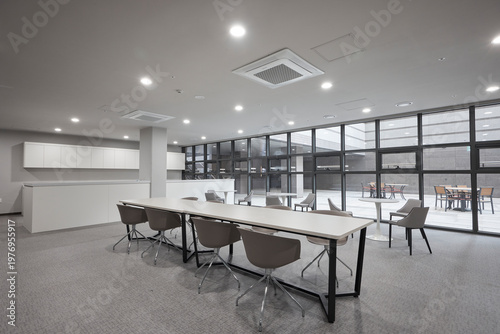 Meeting room with large windows and grouped tables in contemporary interior