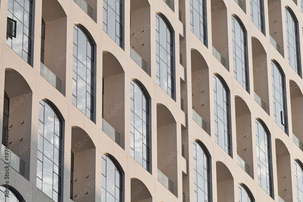 Fototapeta premium Geometric facade of repeating arched windows in contemporary apartment building