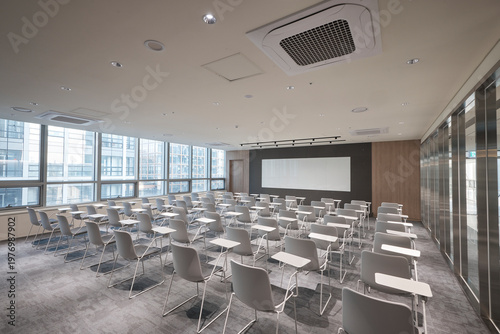 Bright classroom with tables and presentation wall in modern school building