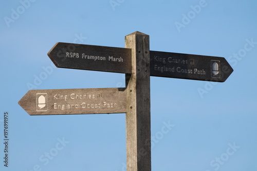 Coastal Path Sign Post - King Charles 111 Coast Path Sign - Direction RSPB close up with blue sky - Coastal Walking route