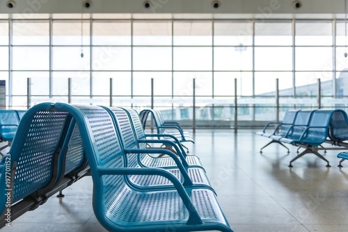 Generative Ai depicts an empty modern airport terminal featuring blue seating arrangements and