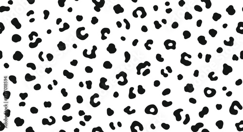 Seamless black and white animal print pattern featuring irregular spots inspired by the fur of a leopard or cheetah on a white base.