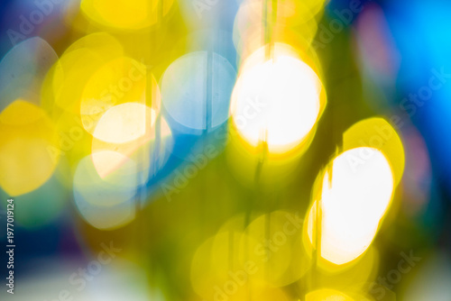 Abstract colorful bokeh lights background with yellow and blue glow