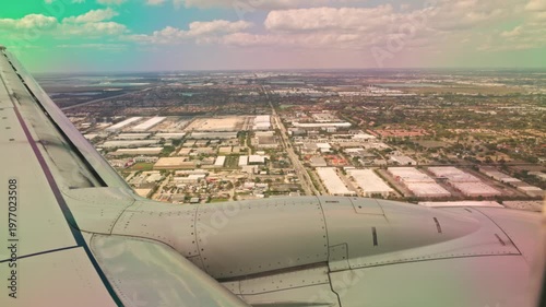 Beautiful view of airplane wing during landing over Miami cityscape with urban grid and cloudy sky. Miami. USA.