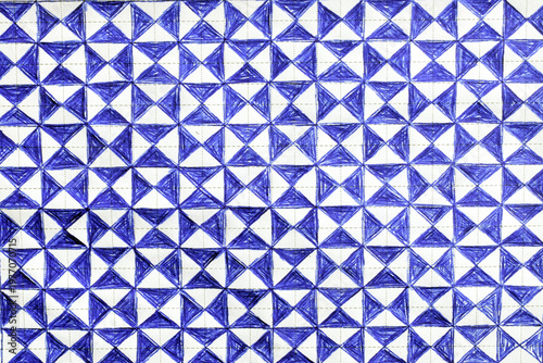 A geometric pattern drawn with blue pen on grid paper. An abstract design consisting of repeating squares, each divided into four triangles.