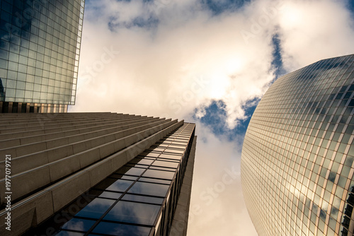 Clouds above modern skyscraper architecture in Paris La Defense suggesting corporate office finance business presence in a rising financial district