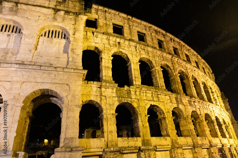 Naklejka premium Pula arena ancient roman amphitheater illuminated at night