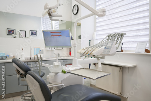 Interior of modern dental clinic with specialized medical unit and monitor. Professional workplace for stomatology treatment and oral hygiene in bright clinical environment.