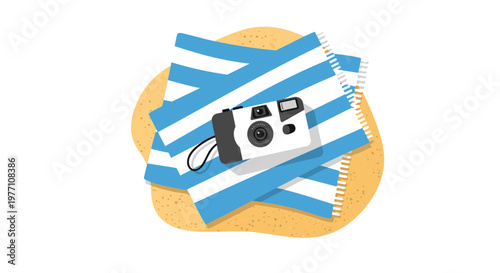A modern white and grey compact camera sits atop a neatly folded blue and white striped beach towel resting on a patch of golden coastal beach sand.