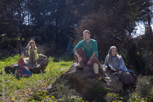 фотографія A family of four people dressed in medieval-inspired attire are gathered in a su