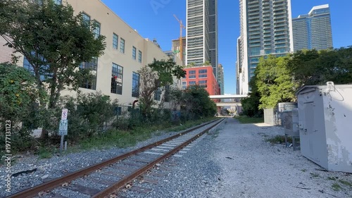 Florida East Coast Railway tracks in Downtown Miami next to the Freedom tower. This line goes to Port Miami. People and cars are crossing tracks. Miami, Florida 