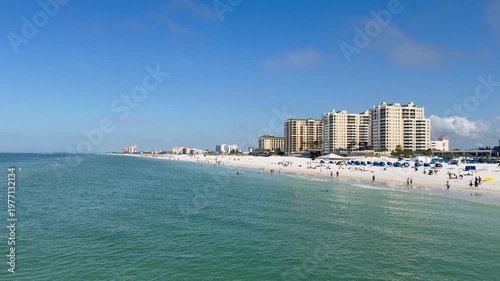 Panoramic, scenic view of Clearwater Island Beach skyline. People are swimming and walking around white sand beach. High rise hotel buildings. Clearwater Beach, Florida 