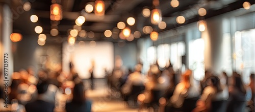 Blurred indoor event with audience, speaker, and warm bokeh lights
