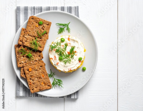 Plate of food with crackers, dip, and greens