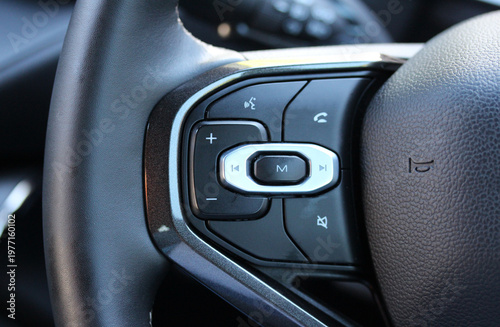 Close up of audio controls on a modern vehicle steering wheel