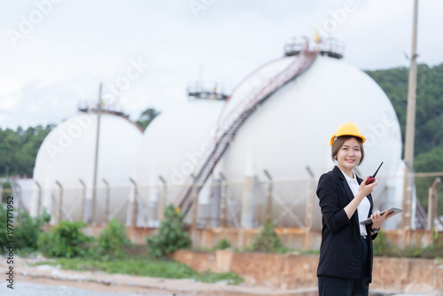 The Female engineer supervises operations in the oil refinery, supporting the export business and ensuring energy production aligns with global market requirements.