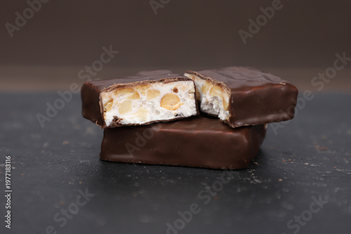 Chocolate bars with nuts on a dark background, close-up