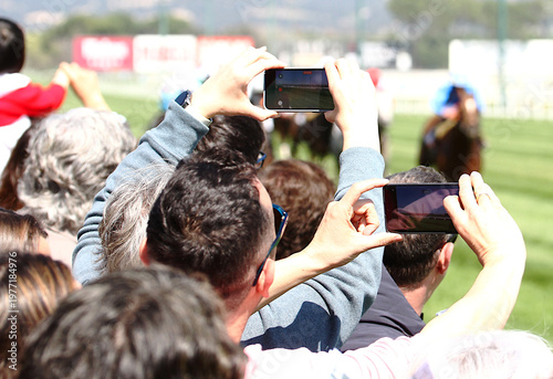 фотографія Público, espectadores y ambiente con teléfono móvil y smartphone en hipódromo gr