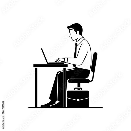 Businessman working on laptop at desk with briefcase nearby in office setting