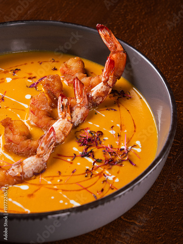 Creamy pumpkin soup topped with grilled shrimps