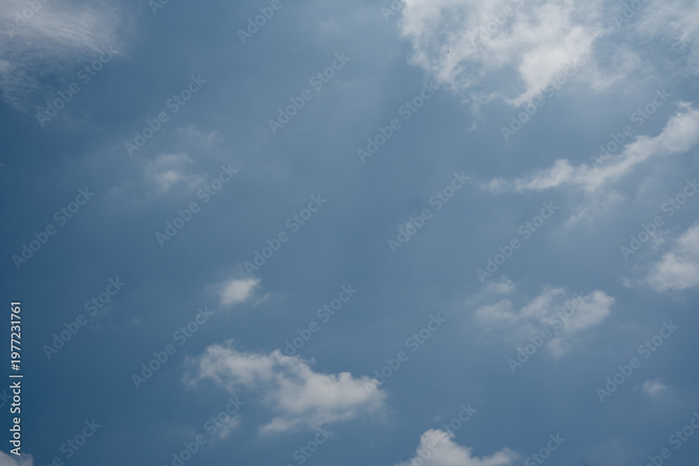 Fototapeta premium Scattered white clouds and wisps in a bright blue sky