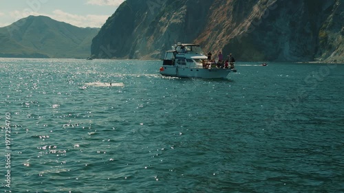 Kamchatka, Russia - August 26, 2025: Killer whales swam close to yacht carrying tourists and released plumes of steam as they surfaced. Slow motion. Travel and tourism concept