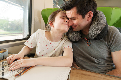 Father and daughter traveling together by train
