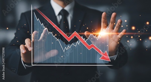 A businessman analyzing a declining stock market graph with a red arrow pointing downwards