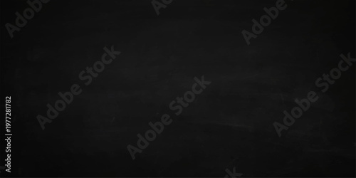 Vintage dark grey chalkboard background with a scratched grunge texture and old rough black stone wall pattern for a blank aged backdrop design