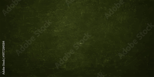 A vintage aged green grunge background features a dark textured paper pattern with rough blank copy space on a dirty retro wall canvas