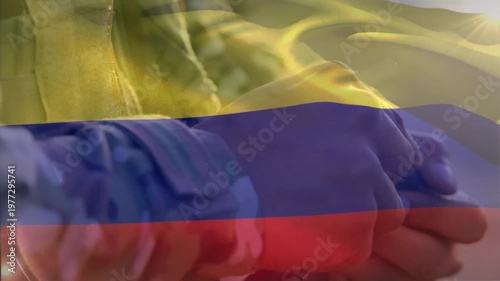 Animation of flag of colombia waving over cropped hands of soldier refilling magazine with bullets