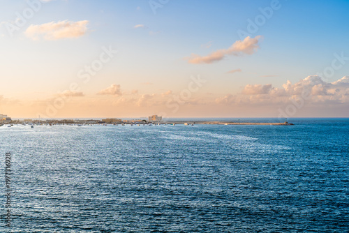 Obraz na plátně Coastal harbor with boats and calm sea under soft sunset light in Alexandria Egy