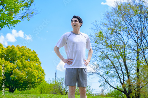 Bild auf Leinwand 公園でストレッチをする日本人男性
