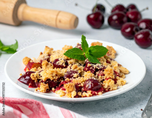 A plate of fruit crumble dessert with chopped rhubarb and cherries, topped with fresh mint. Ai