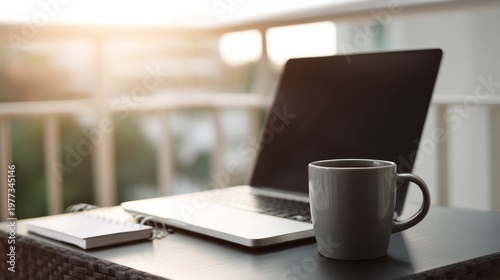 Home office desk with closed laptop, ceramic mug, and notepad near balcony door