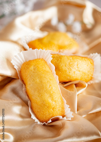 Golden snack cakes resting on elegant satin fabric