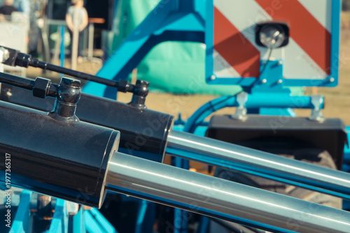 Black pistons or actuators in blue pneumatic or hydraulic machine. Technology