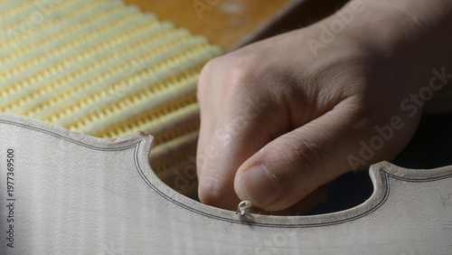Fotografie Close up on a Luthier's Hand Carefully Shaping a Violin Body with Precision and