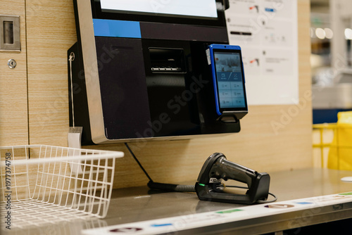 The cashier is using a scanner to settle the payment.