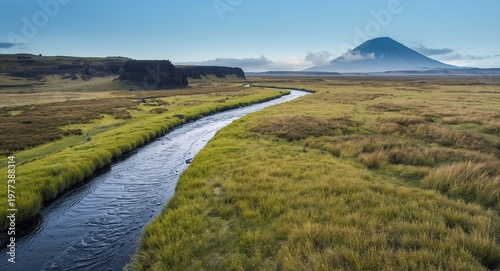 Winding River Through Grassland with Mountains in the Background: Scenic Landscape.