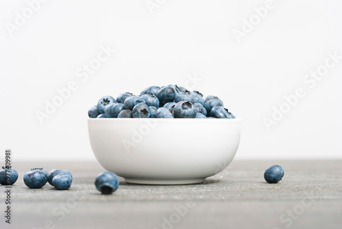 bilberry fruits at china bowl, on dark wood table