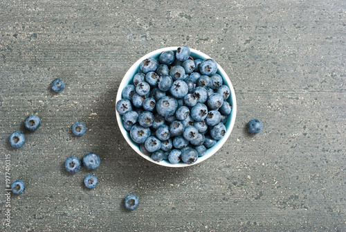 bilberry fruits at china bowl, on dark wood table