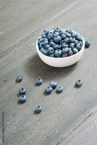 bilberry fruits at china bowl, on dark wood table