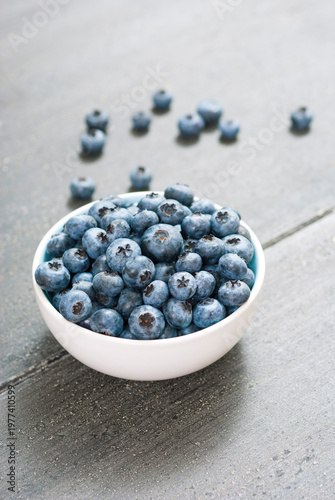 bilberry fruits at china bowl, on dark wood table