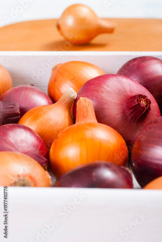 onions on white wood tray, wooden table background