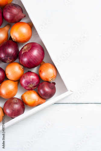 onions on white wood tray, wooden table background